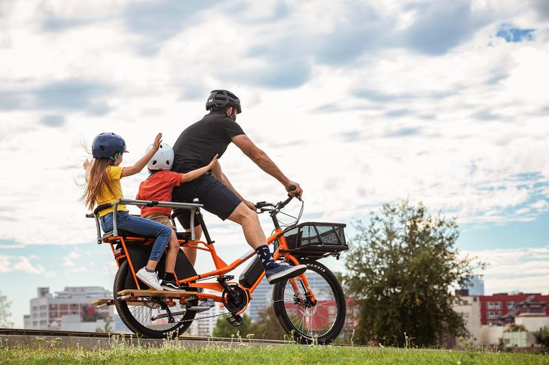 Adult carrying another adult on a cargo bike